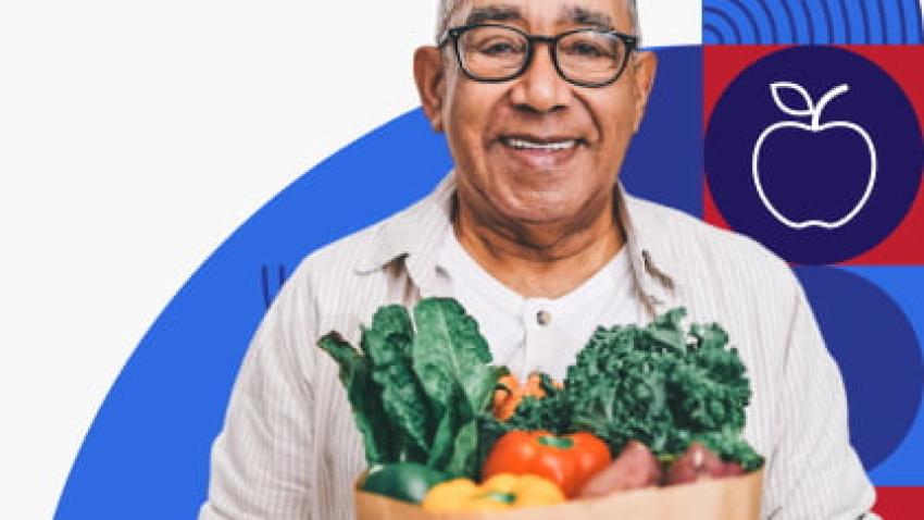 A man holding a paper bag filled with vegetables.