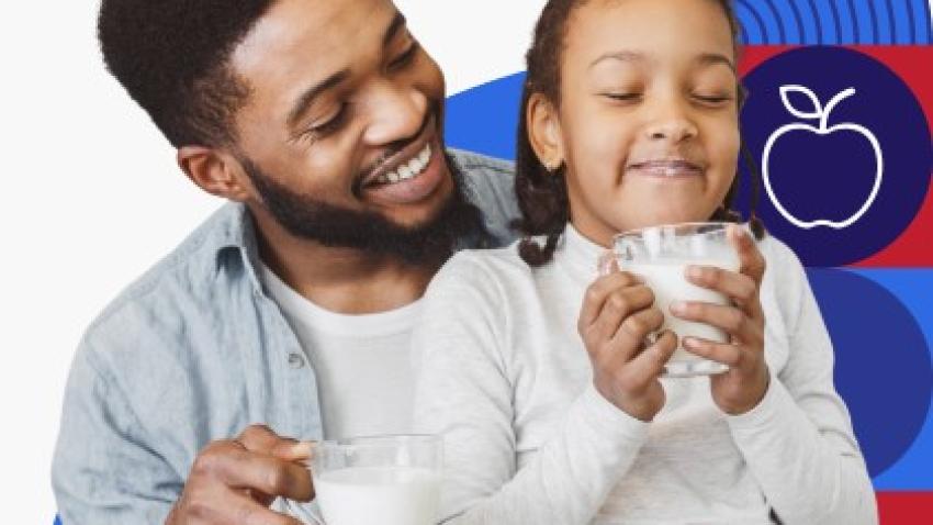 Un padre de raza negra y su hija beben juntos unos vasos de leche.